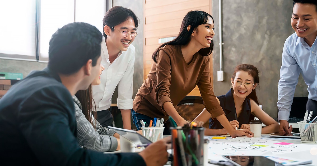 Group of young people working in a shared desk during a meeting