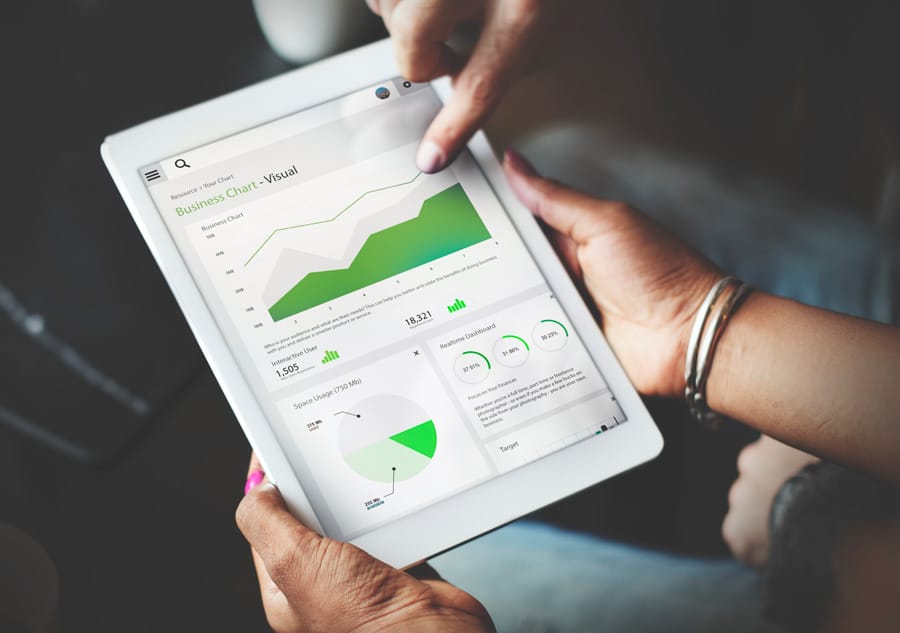 People viewing a dashboard on a tablet, illustrating real-time insights powered by data analytics.