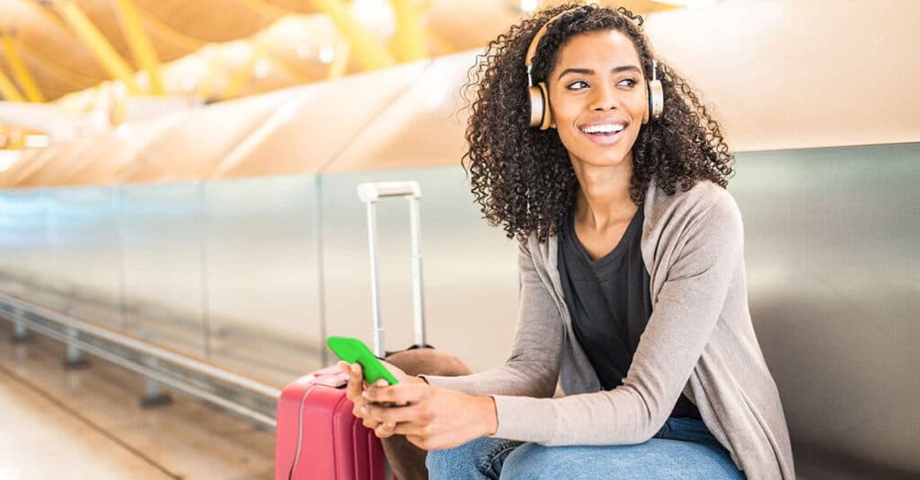 Woman waiting in an airport terminal while listening to music