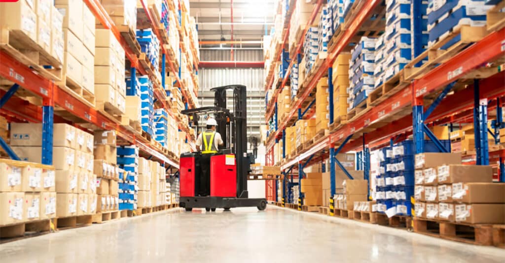 Worker operating a forklift in a warehouse environment.